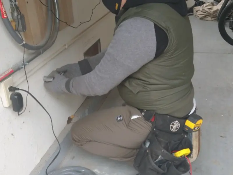 Electrician performing outlet wiring in a Stockbridge garage